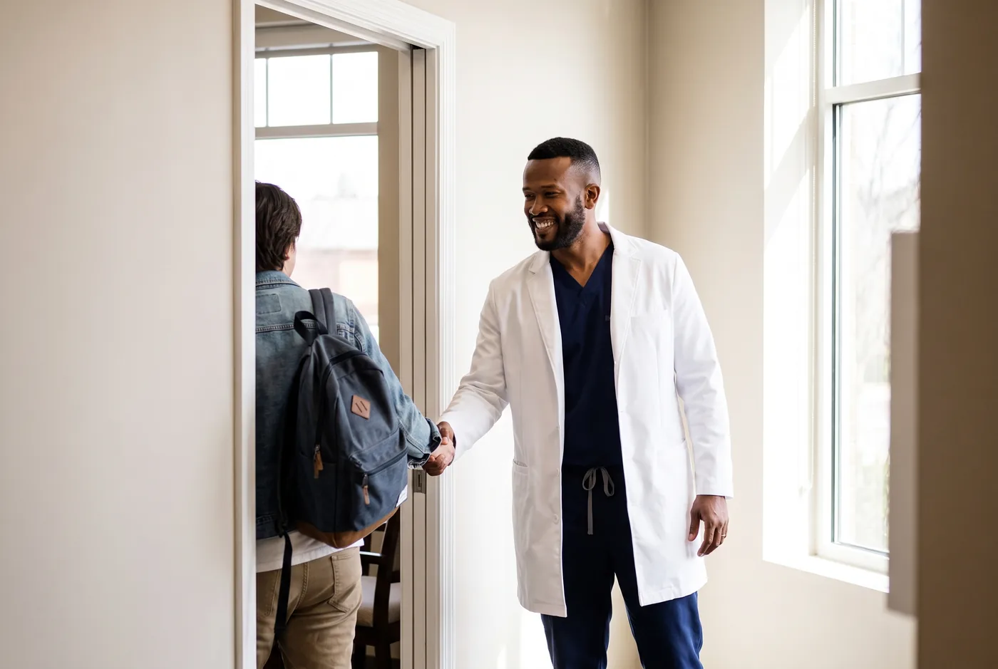 Dr. Peter K. Cudjoe greeting an arriving patient at the door of a consultation room